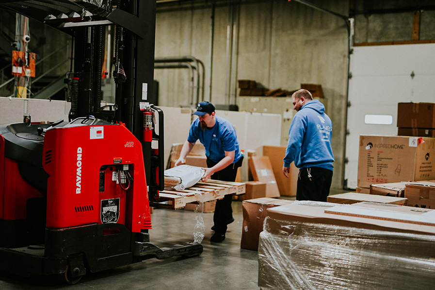 Staff moving boxes off a forklift